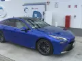 Niebieska Toyota Mirai na stacji wodorowej. Zastanawiasz się nad toyota mirai cena?