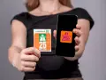 Kobieta trzyma w dłoniach winietę szwajcaria i smartfon z aplikacją.