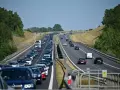 Korek na autostradzie bursztynowej. Długi sznur samochodów i ciężarówek sunie powoli w upalny dzień.