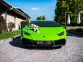 Jaskrawozielone Lamborghini Huracan z bukietem kwiatów na masce i napisem "Młoda Para". Zastanawiasz się, ile kosztuje Lamborghini Huracan?