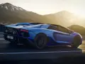 Niebieski Lamborghini Aventador pędzi po górskiej drodze. Choć trudno określić, ile pali Lamborghini Aventador, jego moc jest niezaprzeczalna.