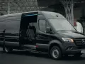 Czarny Mercedes Sprinter z otwartymi drzwiami, wnętrze z wygodnymi fotelami. Zastanawiasz się, ile kosztuje bus do Francji?