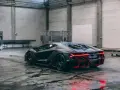 Czarny Lamborghini Centenario z czerwonymi akcentami, stojący w garażu. Zastanawiasz się, ile kosztuje Lamborghini Centenario?