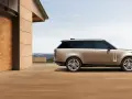 Elegancki Range Rover w kolorze piaskowym, zaparkowany przed nowoczesnym domem z drewnianymi drzwiami. Sprawdź range rover cena!