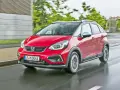 Czerwony Honda Jazz 4 w wersji Crosstar z czarnym dachem i relingami, porusza się po mokrej drodze.