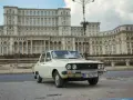 Biała Dacia 1300 na tle monumentalnego Pałacu Parlamentu w Bukareszcie.