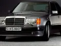 Klasyczny youngtimer, szary Mercedes-Benz W124 z charakterystyczną kratką i reflektorami.