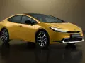 Złoty Toyota Prius Plug-in Hybrid, kiedy nowy prius w polsce, prezentuje się nowocześnie z czarnym dachem i eleganckimi felgami.