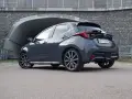 Szary Toyota Yaris Hybrid stoi przed tunelem. Dowiedz się, ile pali Toyota Yaris Hybrid, analizując jego osiągi.