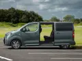Zielony bus 9 osobowy z otwartymi drzwiami, idealny na rodzinne wycieczki. Jaki wybrać?