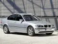 Srebrne e46 bmw sedan stoi przed nowoczesnym budynkiem z żaluzjami.