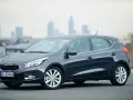 Ciemnoszary Kia Ceed 1. hatchback stoi na tle miejskiej panoramy.