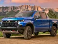 Niebieski Chevrolet pickup ZR2 na drodze w górach, gotowy na przygodę.