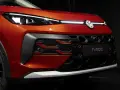 Nowy VW T-Roc w kolorze pomarańczowym prezentuje się z przodu z charakterystycznym grillem i nowoczesnymi światłami IQ.LIGHT.