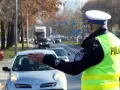 Policjant kieruje ruchem na ulicy. Kierowca zatrzymuje się, bo zgubił prawo jazdy i boi się kontroli.