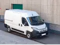 Biały bus 9 osobowy Fiat Ducato, zaparkowany przy betonowej ścianie. Zastanawiasz się, ile pali bus 9 osobowy?