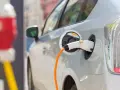 Samochód elektryczny podłączony do ładowarki. Zastanawiasz się, co ile trzeba ładować samochód elektryczny? To zależy od wielu czynników, ale zazwyczaj raz na kilka dni.
