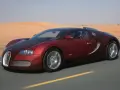 Czerwone Bugatti Veyron sunie po pustynnej drodze. Zastanawiasz się, ile kosztuje taki luksus?