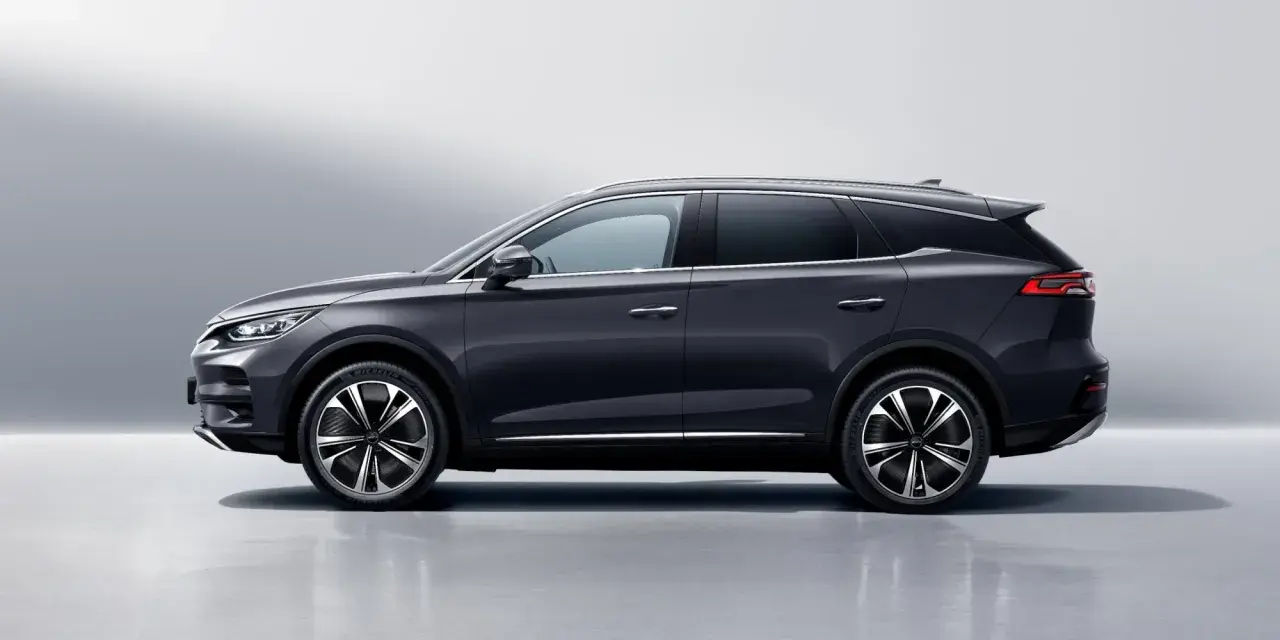 Ciemnoszary BYD Tang, SUV z eleganckimi felgami, prezentuje się na tle jasnej ściany. Sprawdź byd tang cena i jego możliwości.