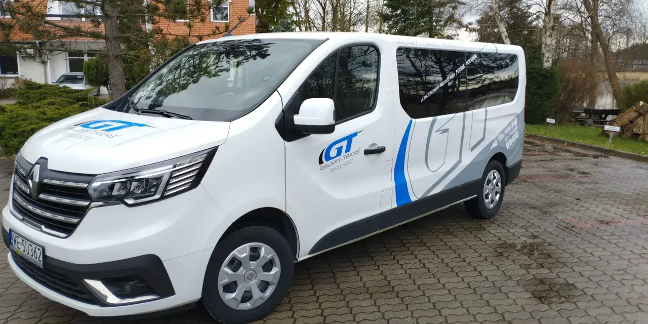 Biały bus Galaxy-Trans z logo GT. Zapytaj, ile kosztuje bus do Holandii, by poznać ceny przejazdów.