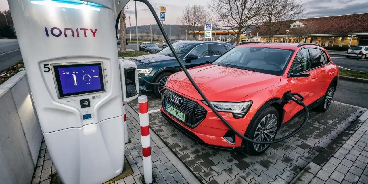 Na stacji Ionity czerwony Audi e-tron ładuje się. Ekran pokazuje 91% naładowania i 77kW mocy. Ile trwa ładowanie samochodu elektrycznego na stacji?