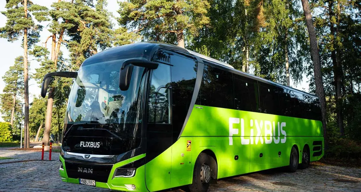 Zielony polski bus FlixBus stoi na brukowanym placu. Zastanawiasz się, jak oddać bilet?