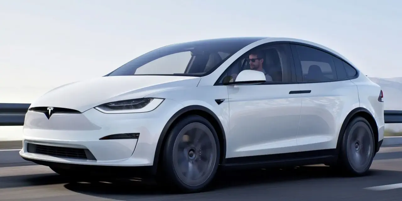 Biała Tesla Model X jedzie po drodze. Zastanawiasz się, ile kosztuje Tesla Model X?