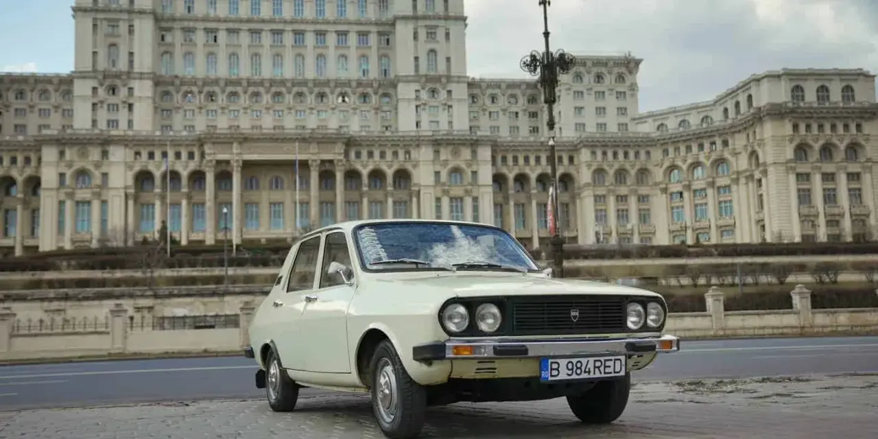 Biała Dacia 1300 na tle monumentalnego Pałacu Parlamentu w Bukareszcie.