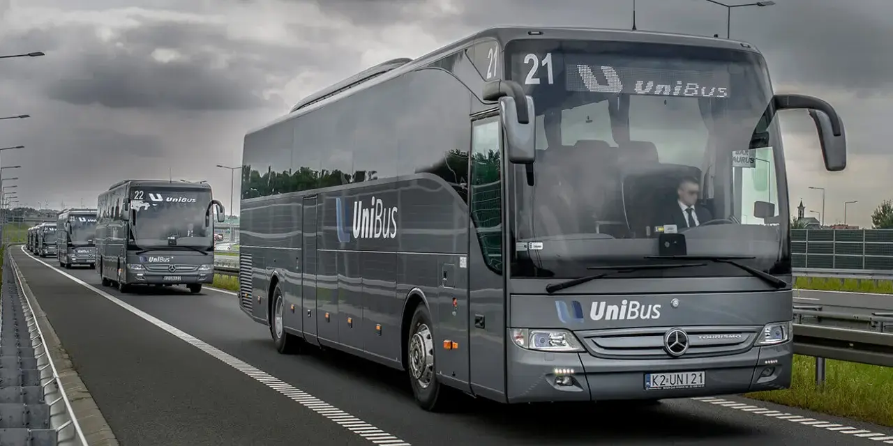 Szary bus UniBus z numerem 21 jedzie autostradą. To jeden z wielu pojazdów na trasie Kraków-Katowice.