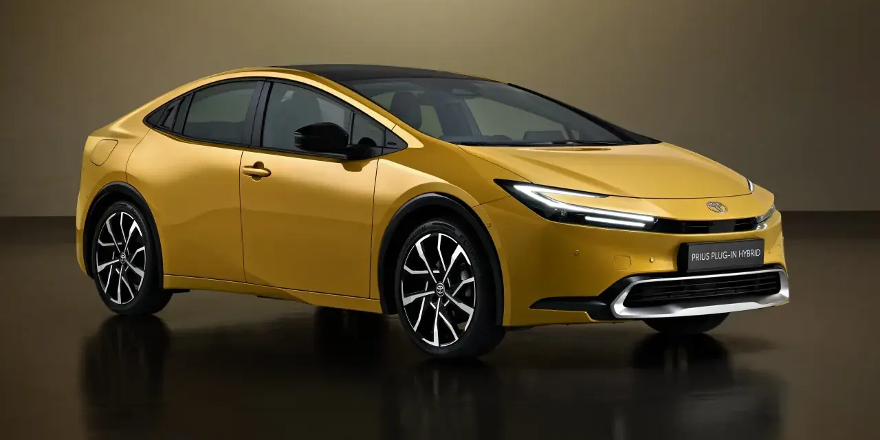 Złoty Toyota Prius Plug-in Hybrid, kiedy nowy prius w polsce, prezentuje się nowocześnie z czarnym dachem i eleganckimi felgami.