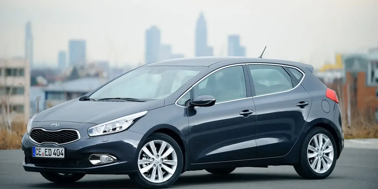 Ciemnoszary Kia Ceed 1. hatchback stoi na tle miejskiej panoramy.