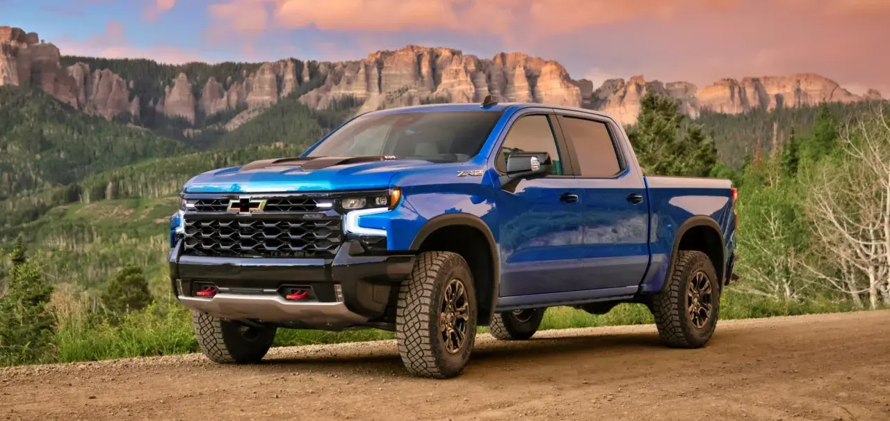 Niebieski Chevrolet pickup ZR2 na drodze w górach, gotowy na przygodę.