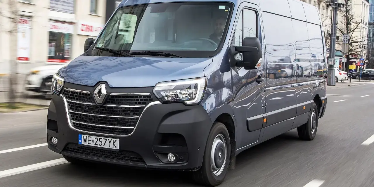 Niebieski bus 11 osobowy Renault Master jedzie ulicą. Jakie prawo jazdy jest potrzebne do jego prowadzenia?