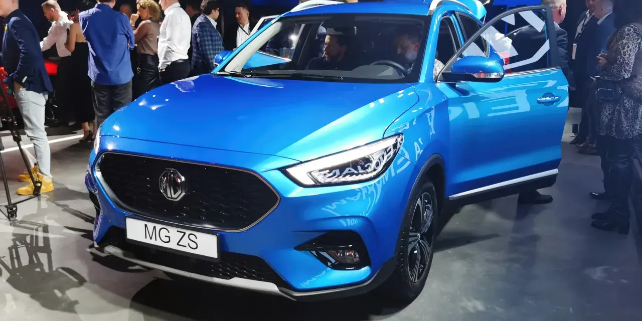 Błękitny MG ZS na prezentacji. Ludzie oglądają nowy model marki MG.