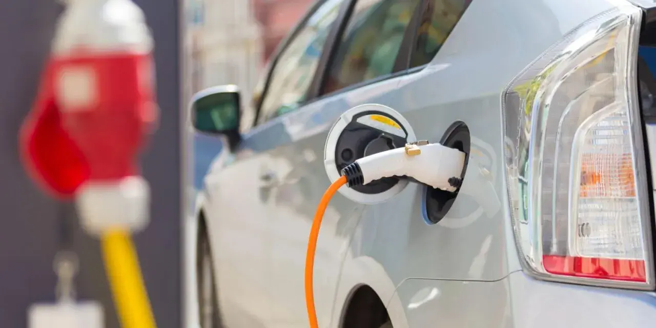 Samochód elektryczny podłączony do ładowarki. Zastanawiasz się, co ile trzeba ładować samochód elektryczny? To zależy od wielu czynników, ale zazwyczaj raz na kilka dni.