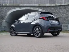 Szary Toyota Yaris Hybrid stoi przed tunelem. Dowiedz się, ile pali Toyota Yaris Hybrid, analizując jego osiągi.