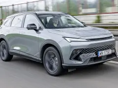 Szary SUV Beijing 5 jedzie po drodze. Kierowca w okularach prowadzi auto.