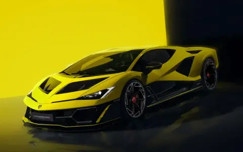 Żółte Lamborghini z czarnymi akcentami na tle żółtej ściany i ciemnego tła.