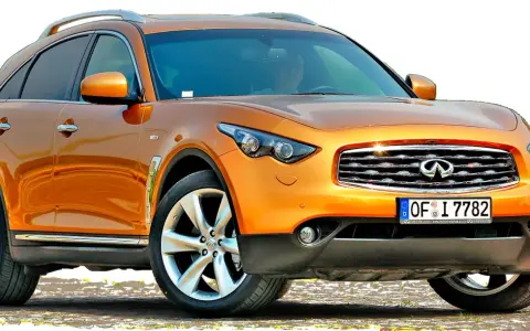 Pomarańczowy infiniti samochód z chromowanymi detalami i felgami, gotowy na przygodę.