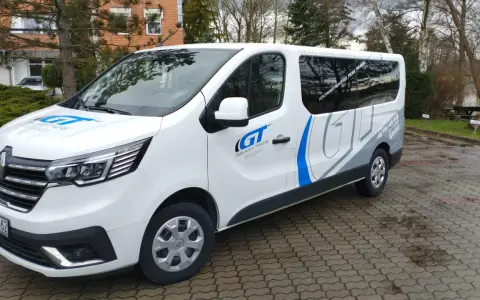 Biały bus Galaxy-Trans z logo GT. Zapytaj, ile kosztuje bus do Holandii, by poznać ceny przejazdów.