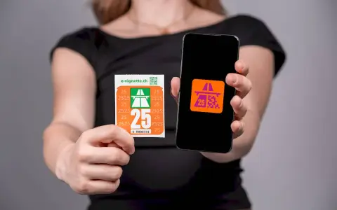 Kobieta trzyma w dłoniach winietę szwajcaria i smartfon z aplikacją.
