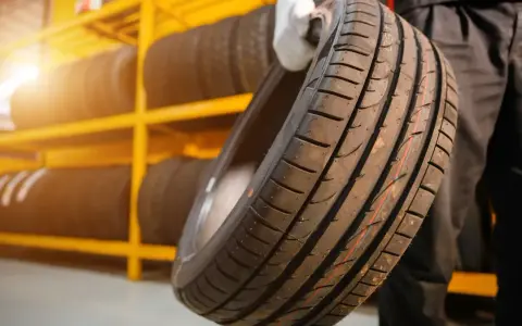 Nowe opony na żółtej półce. Czy koło zapasowe jest obowiązkowe? Warto mieć zapas, gdy coś się stanie.