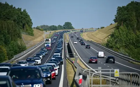 Korek na autostradzie bursztynowej. Długi sznur samochodów i ciężarówek sunie powoli w upalny dzień.