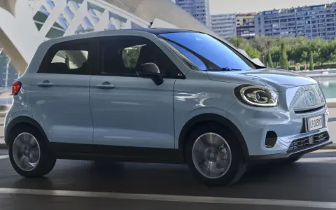 Jasnoszary Leapmotor T03 na tle nowoczesnej architektury. Sprawdź, jaka jest leapmotor t03 cena i czy to auto dla Ciebie.