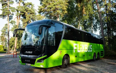 Zielony polski bus FlixBus stoi na brukowanym placu. Zastanawiasz się, jak oddać bilet?