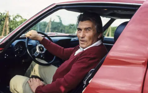 Ferruccio Lamborghini, kto stworzył Lamborghini, siedzi za kierownicą swojego czerwonego supersamochodu.