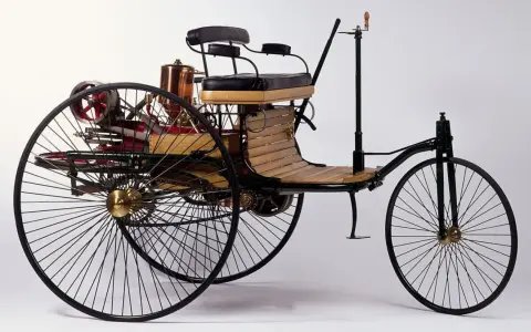 Tricykl Benz Patent-Motorwagen, pierwszy samochód na świecie, z drewnianym siedzeniem i miedzianym kotłem.