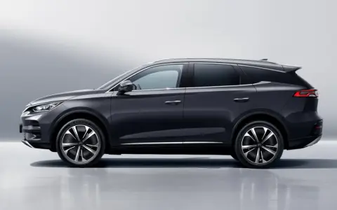 Ciemnoszary BYD Tang, SUV z eleganckimi felgami, prezentuje się na tle jasnej ściany. Sprawdź byd tang cena i jego możliwości.