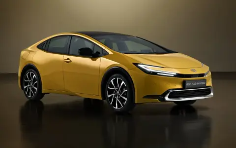 Złoty Toyota Prius Plug-in Hybrid, kiedy nowy prius w polsce, prezentuje się nowocześnie z czarnym dachem i eleganckimi felgami.