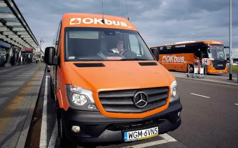 Pomarańczowy bus OKBUS czeka na pasażerów. Zastanawiasz się, ile kosztuje bus z Łodzi do Uniejowa? Sprawdź ofertę przewoźnika.